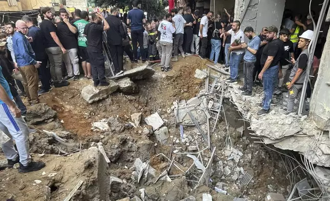 People gather at the scene of an Israeli missile strike in the southern suburbs of Beirut, Friday, Sept. 20, 2024. (AP Photo/Bilal Hussein)