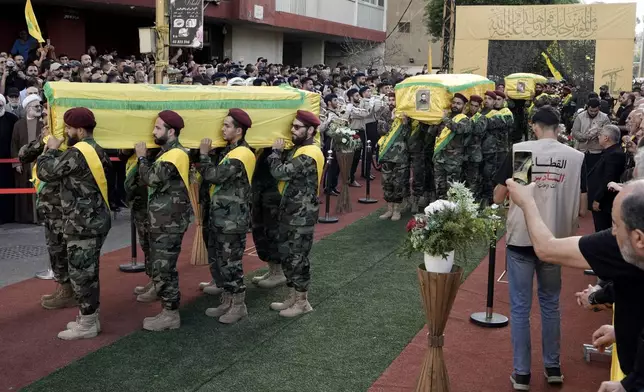 Hezbollah fighters carry the coffins of their comrades who were killed in Friday's Israeli strike, during their funeral procession in the southern suburb of Beirut, Lebanon, Saturday, Sept. 21, 2024. (AP Photo/Bilal Hussein)