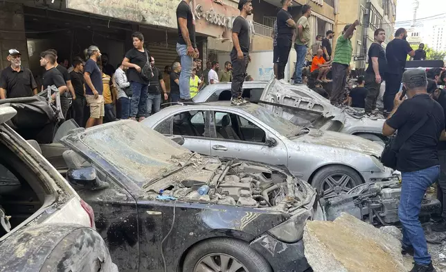 People gather at the scene of an Israeli missile strike in the southern suburbs of Beirut, Friday, Sept. 20, 2024. (AP Photo/Bilal Hussein)