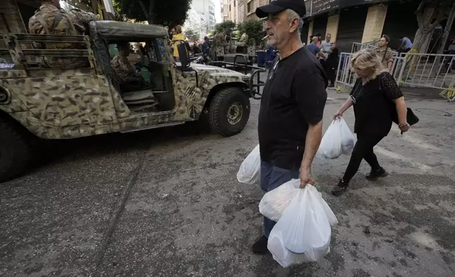 Lebanese soldiers drive near the site of Friday's Israeli strike in Beirut's southern suburb, Sunday, Sept. 22, 2024. (AP Photo/Bilal Hussein)