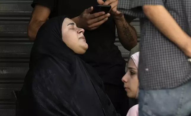 Relatives of the victims react near the site of Friday's Israeli strike in Beirut's southern suburbs, Saturday, Sept. 21, 2024. (AP Photo/Bilal Hussein)