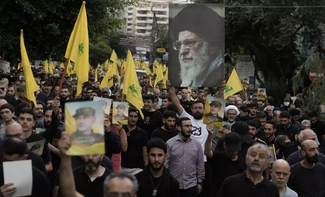 Hezbollah supporters carry pictures of Hezbollah commander Ibrahim Akil and Supreme Leader Ayatollah Ali Khamenei during Akil's funeral procession in Beirut's southern suburb, Sunday, Sept. 22, 2024. (AP Photo/Bilal Hussein)