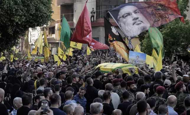 Mourners carry the coffins of Hezbollah fighters who were killed in Friday's Israeli strike, during their funeral procession in the southern suburb of Beirut, Lebanon, Saturday, Sept. 21, 2024. (AP Photo/Bilal Hussein)