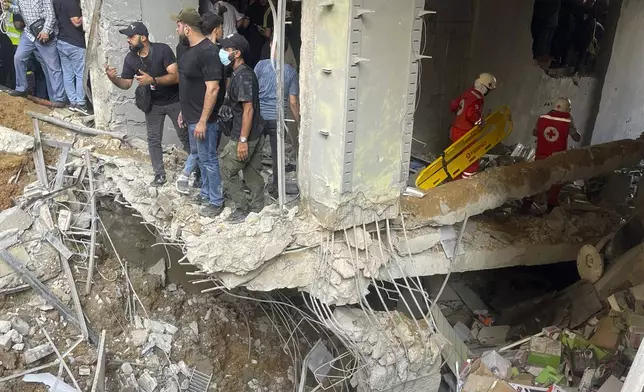 People and rescuers gather at the scene of an Israeli missile strike in the southern suburbs of Beirut, Friday, Sept. 20, 2024. (AP Photo/Bilal Hussein)