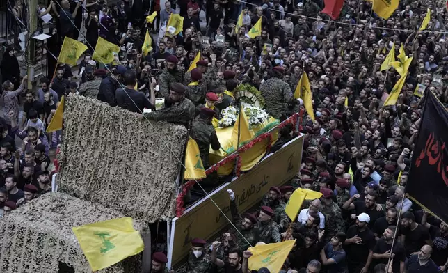 Hezbollah supporters march behind the hearse carrying the coffins of Hezbollah commander Ibrahim Akil and militant Mahmoud Hamad during their funeral procession in Beirut's southern suburb, Sunday, Sept. 22, 2024. (AP Photo/Bilal Hussein)