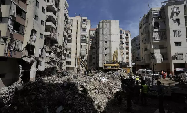 Emergency workers clear the rubble at the site of Friday's Israeli strike in Beirut's southern suburb, Sunday, Sept. 22, 2024. (AP Photo/Bilal Hussein)