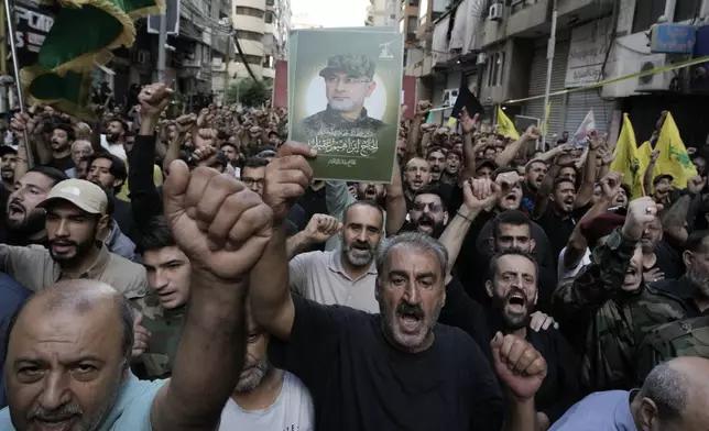 Hezbollah supporters carry pictures of Hezbollah commander Ibrahim Akil, during his funeral procession in Beirut's southern suburb, Sunday, Sept. 22, 2024. (AP Photo/Bilal Hussein)