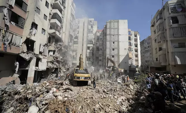 Emergency workers use excavators to clear the rubble at the site of Friday's Israeli strike in Beirut's southern suburbs, Saturday, Sept. 21, 2024. (AP Photo/Bilal Hussein)