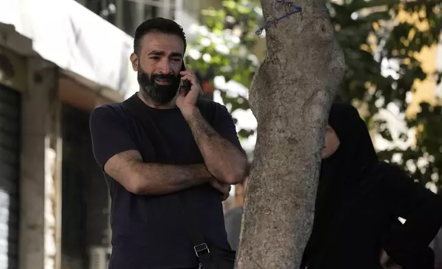 A man reacts as he speaks on the phone near the site of Friday's Israeli strike in Beirut's southern suburbs, Saturday, Sept. 21, 2024. (AP Photo/Bilal Hussein)