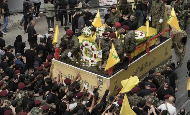 Hezbollah supporters march behind the hearse carrying the coffins of Hezbollah commander Ibrahim Akil and militant Mahmoud Hamad during their funeral procession in Beirut's southern suburb, Sunday, Sept. 22, 2024. (AP Photo/Bilal Hussein)