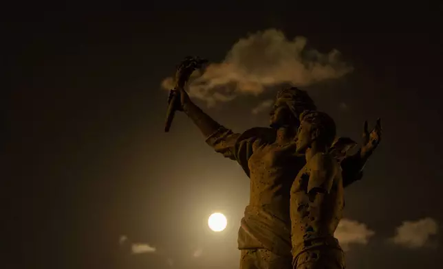 The Supermoon rises beyond the Martyr's statue, in downtown Beirut, Lebanon, Tuesday, Sept. 17, 2024. (AP Photo/Hassan Ammar)