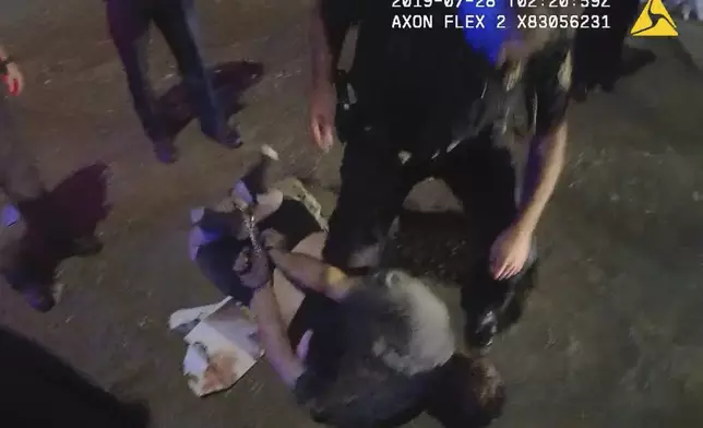 FILE - In this image from Knox County Sheriff's Office body-camera video, cuffs on the wrists and ankles are used to restrain Johnathan Binkley in Knoxville, Tenn., on July 28, 2019. He rolled around for three more minutes, as deputies watched. One thrust a knee into his back, forcing him to be still, and he became unresponsive within a minute. (Knox County Sheriff's Office via AP, File)