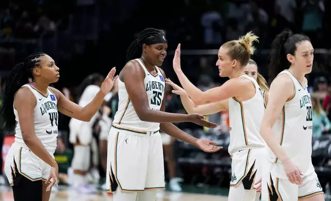 From left, New York Liberty forward Betnijah Laney-Hamilton (44), forward Jonquel Jones (35), forward Leonie Fiebich and forward Breanna Stewart, right, celebrate in the final seconds during the second half of a WNBA basketball game against the Seattle Storm, Friday, Aug. 30, 2024, in Seattle. The Liberty won 98-85. (AP Photo/Lindsey Wasson)