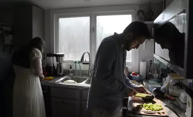 Julia Manetta, left, and her husband, Steven Manetta, a cancer patient, work on dinner Thursday, Aug. 29, 2024, in their Lemont, Ill., home. (AP Photo/Charles Rex Arbogast)