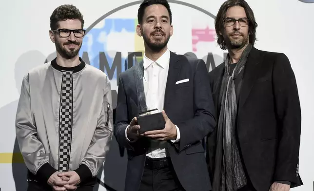 FILE - Brad Delson, from left, Mike Shinoda, and Rob Bourdon of Linkin Park pose in the press room with the award for favorite artist alternative rock at the American Music Awards on Nov. 19, 2017, in Los Angeles. (Photo by Jordan Strauss/Invision/AP, File)