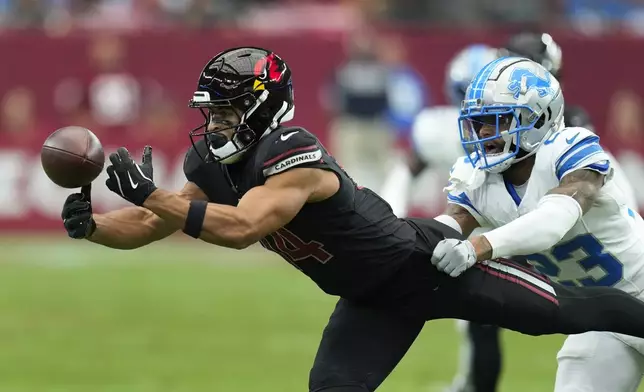 Arizona Cardinals wide receiver Michael Wilson (14) catches a pass as Detroit Lions cornerback Carlton Davis III (23) defends during the first half of an NFL football game Sunday, Sept. 22, 2024, in Glendale, Ariz. (AP Photo/Ross D. Franklin )