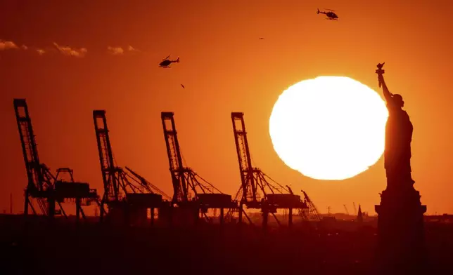 FILE - Cranes at the Port of New York and New Jersey appear behind the Statue of Liberty, Nov. 20, 2022, in a photo taken from New York. (AP Photo/Julia Nikhinson, File)