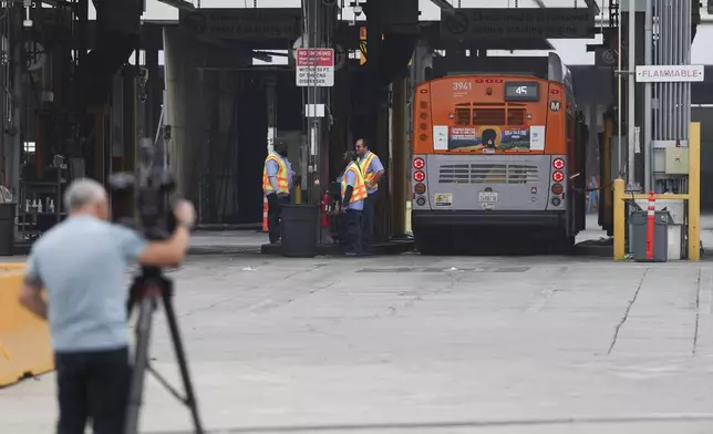 A news camera records in front of a Los Angeles MTA bus depot near the site where overnight a bus was hijacked by an armed subject with passengers on board Wednesday, Sept. 25, 2024, in Los Angeles. One person was fatally shot before police apprehended the suspect. (AP Photo/Ryan Sun)