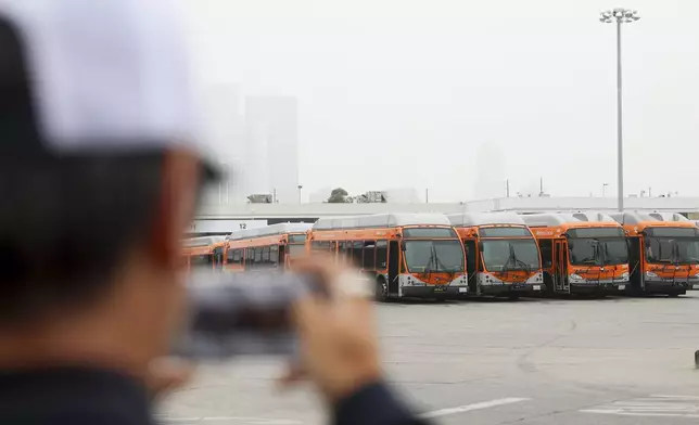 News media prepare to go live in front of a Los Angeles MTA bus depot near the site where overnight a bus was hijacked by an armed subject with passengers on board Wednesday, Sept. 25, 2024, in Los Angeles. One person was fatally shot before police apprehended the suspect. (AP Photo/Ryan Sun)