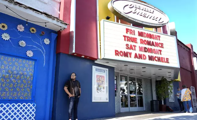 Cinephile Miles Villalon, left, stands underneath the marquee of the New Beverly Cinema revival theater, Friday, Aug. 9, 2024, in Los Angeles. (AP Photo/Chris Pizzello)