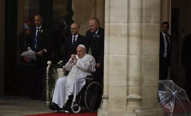 Pope Francis is received by Luxembourg's Prime Minister Luc Frieden, left, as he arrives at the Cercle-Cite convention center in Luxembourg for a meeting with the national authorities and the civil society on the first day of his four-day visit to Luxembourg and Belgium, Thursday, Sept. 26, 2024. (AP Photo/Omar Havana)