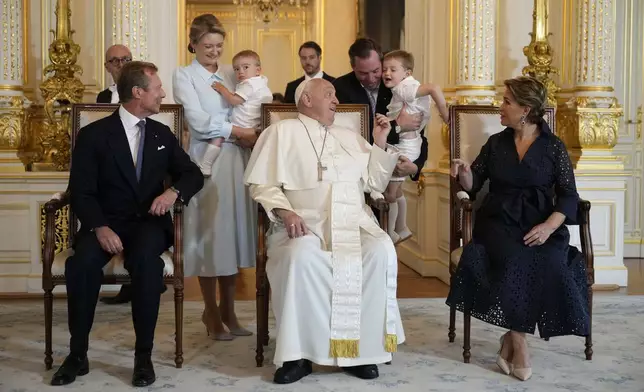 Pope Francis poses for a picture with Luxembourg's Grand Duke Henri, left, Grand Duchess Maria Teresa, right, Prince Guillaume Jean Joseph Marie, background right, his wife Countess Stephanie de Lannoy, background left, with their children during his visit at the Grand Ducal Palace, in Luxembourg, Thursday, Sept. 26, 2024. (AP Photo/Andrew Medichini)