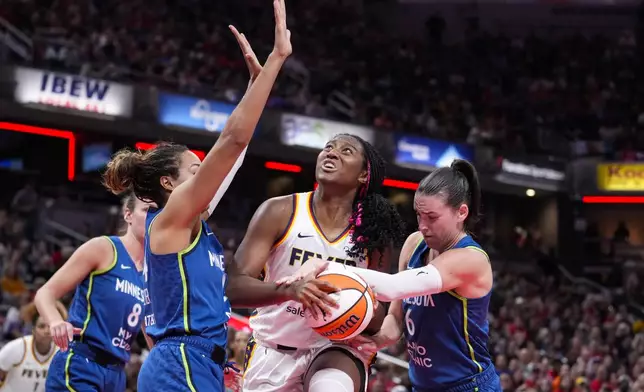 Indiana Fever forward Aliyah Boston (7) is fouled as she shoots between Minnesota Lynx forward Napheesa Collier, left, and forward Bridget Carleton (6) in the second half of a WNBA basketball game in Indianapolis, Friday, Sept. 6, 2024. (AP Photo/Michael Conroy)