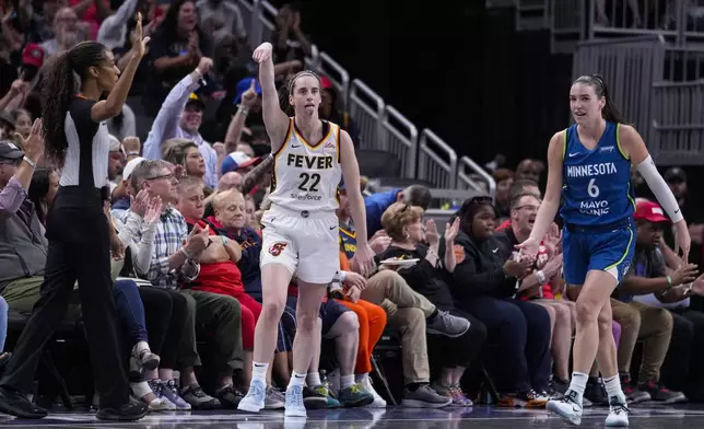 Indiana Fever guard Caitlin Clark (22) reacts after a three-point basket in front of Minnesota Lynx forward Bridget Carleton (6) in the first half of a WNBA basketball game in Indianapolis, Friday, Sept. 6, 2024. (AP Photo/Michael Conroy)