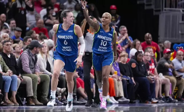 Minnesota Lynx guard Courtney Williams (10) and forward Bridget Carleton (6) celebrate after William hits a three-point basket against the Indiana Fever in the second half of a WNBA basketball game in Indianapolis, Friday, Sept. 6, 2024. (AP Photo/Michael Conroy)