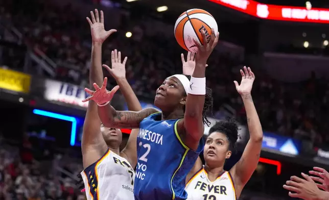 Minnesota Lynx forward Myisha Hines-Allen (22) shoots in front of Indiana Fever forward Aliyah Boston (7) and forward Damiris Dantas (12) in the first half of a WNBA basketball game in Indianapolis, Friday, Sept. 6, 2024. (AP Photo/Michael Conroy)