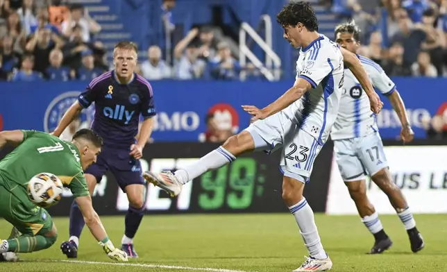 Montreal's Caden Clark (23) scores against Charlotte goalkeeper Kristijan Kahlina (1) during the first half of an MLS soccer match in Montreal, Saturday, Sept. 14, 2024. (Graham Hughes/The Canadian Press via AP)