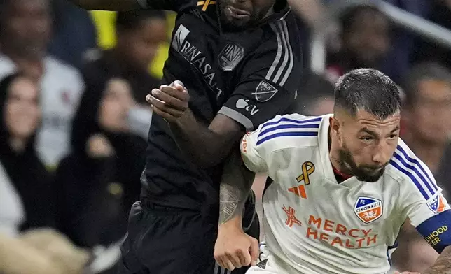 Nashville SC defender Shaq Moore (18) heads the ball over FC Cincinnati midfielder Luciano Acosta (10) during the second half of an MLS soccer match Saturday, Sept. 21, 2024, in Nashville, Tenn. (AP Photo/George Walker IV)