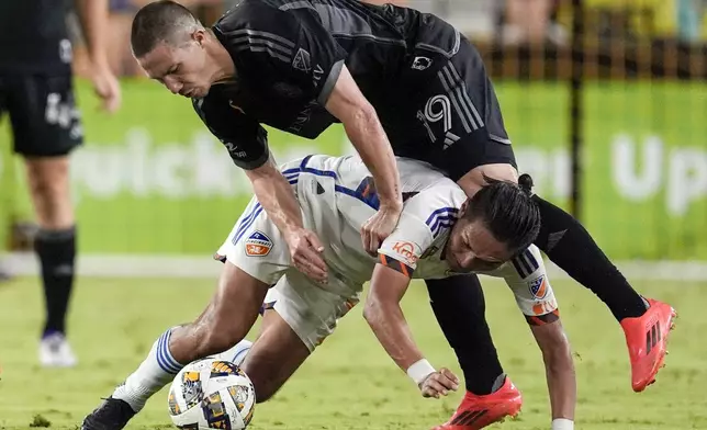 FC Cincinnati forward Yuya Kubo, below, collides with Nashville SC midfielder Alex Muyl (19) during the second half of an MLS soccer match Saturday, Sept. 21, 2024, in Nashville, Tenn. (AP Photo/George Walker IV)