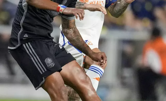 Nashville SC midfielder Anibal Godoy, left, kicks the ball past FC Cincinnati midfielder Luciano Acosta, right, during the second half of an MLS soccer match Saturday, Sept. 21, 2024, in Nashville, Tenn. (AP Photo/George Walker IV)