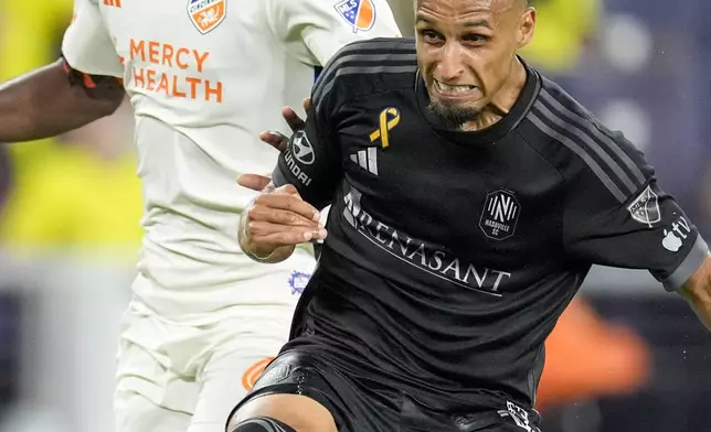 Nashville SC midfielder Hany Mukhtar, right, kicks the ball past FC Cincinnati defender Chidozie Awaziem, right, during the second half of an MLS soccer match Saturday, Sept. 21, 2024, in Nashville, Tenn. (AP Photo/George Walker IV)