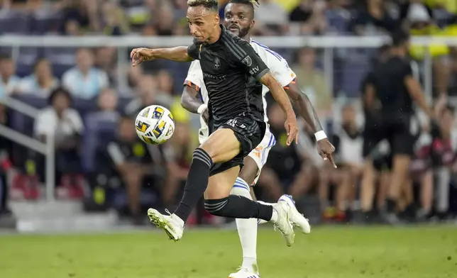 Nashville SC midfielder Hany Mukhtar, left, chases the ball past FC Cincinnati defender Chidozie Awaziem, right, during the second half of an MLS soccer match Saturday, Sept. 21, 2024, in Nashville, Tenn. (AP Photo/George Walker IV)