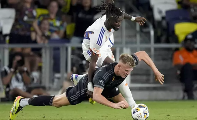 FC Cincinnati defender Chidozie Awaziem, left, pushes Nashville SC forward Sam Surridge, right, to the pitch during the first half of an MLS soccer match Saturday, Sept. 21, 2024, in Nashville, Tenn. (AP Photo/George Walker IV)