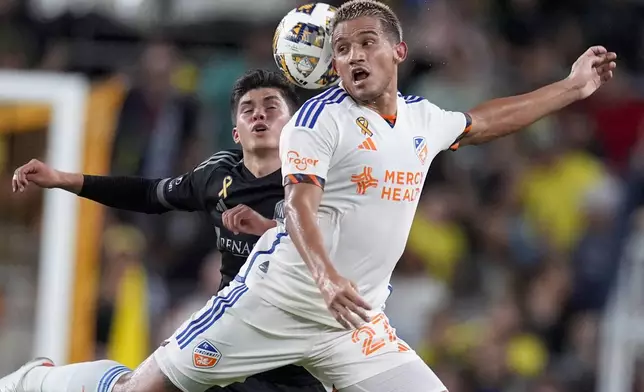 Nashville SC midfielder Jonathan Perez, left, and FC Cincinnati midfielder Yamil Asad (27) battle for the ball during the first half of an MLS soccer match Saturday, Sept. 21, 2024, in Nashville, Tenn. (AP Photo/George Walker IV)