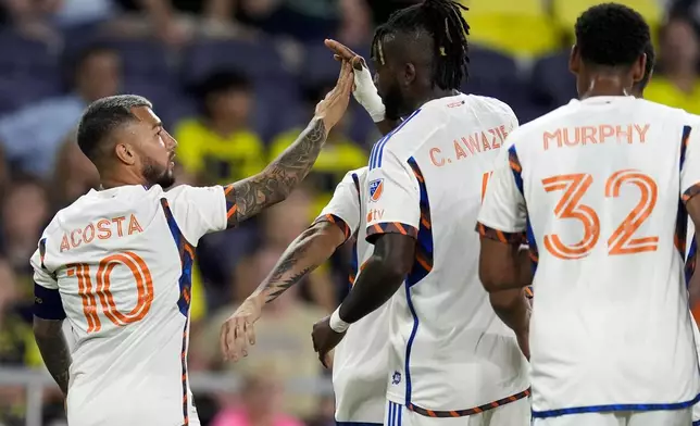 FC Cincinnati midfielder Luciano Acosta (10) celebrates a goal with defender Chidozie Awaziem, second from right, during the first half of an MLS soccer match against Nashville SC, Saturday, Sept. 21, 2024, in Nashville, Tenn. (AP Photo/George Walker IV)