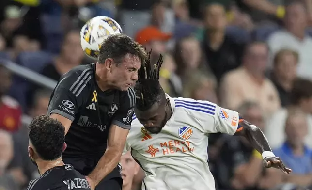 FC Cincinnati defender Chidozie Awaziem, right, heads the ball past Nashville SC defender Taylor Washington, left, during the first half of an MLS soccer match Saturday, Sept. 21, 2024, in Nashville, Tenn. (AP Photo/George Walker IV)