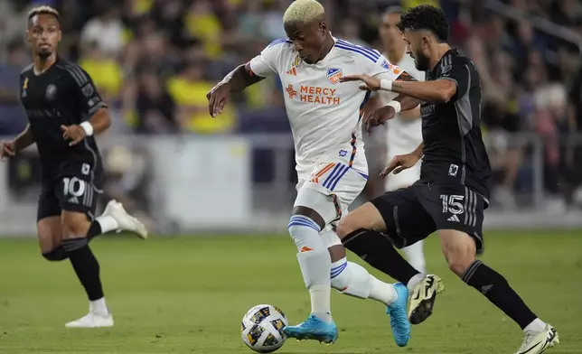 FC Cincinnati forward Sergio Santos, center, kicks the ball past Nashville SC midfielder Patrick Yazbek (15) during the first half of an MLS soccer match Saturday, Sept. 21, 2024, in Nashville, Tenn. (AP Photo/George Walker IV)