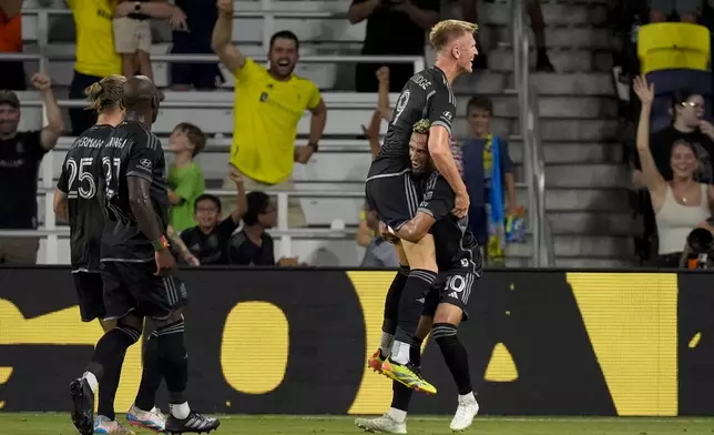 Nashville SC forward Sam Surridge (9) and midfielder Hany Mukhtar (10) celebrate a goal during the first half of an MLS soccer match against FC Cincinnati, Saturday, Sept. 21, 2024, in Nashville, Tenn. (AP Photo/George Walker IV)