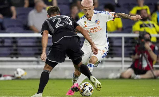 FC Cincinnati midfielder Luca Orellano, right, moves the ball past Nashville SC defender Taylor Washington (23) during the first half of an MLS soccer match Saturday, Sept. 21, 2024, in Nashville, Tenn. (AP Photo/George Walker IV)