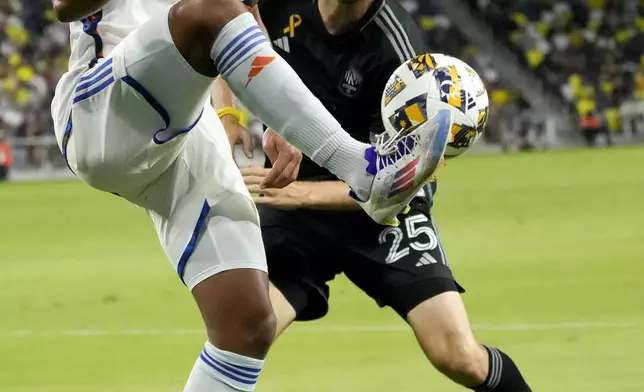 FC Cincinnati forward Nicholas Gioacchini, left, kicks the ball past Nashville SC defender Walker Zimmerman (25) during the first half of an MLS soccer match Saturday, Sept. 21, 2024, in Nashville, Tenn. (AP Photo/George Walker IV)