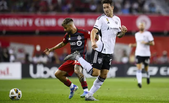 D.C. United defender Aaron Herrera (22) passes the ball back past Toronto FC forward Lorenzo Insigne (24) during the first half of a MLS soccer match in Toronto on Saturday, Aug. 31, 2024. (Christopher Katsarov/The Canadian Press via AP)