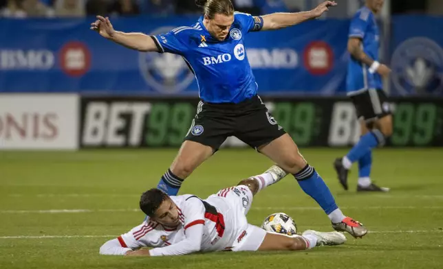 San Jose Earthquakes' Hernan Lopez, bottom, slides in to block the pass of CF Montreal's Samuel Piette during the first half of an MLS soccer match in Montreal, Saturday, September 28, 2024. (Peter McCabe/The Canadian Press via AP)