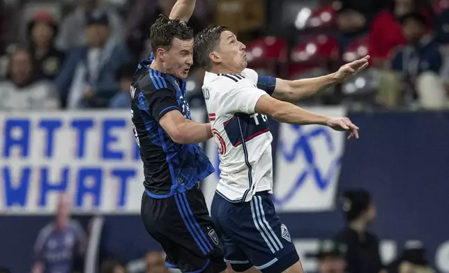 San Jose Earthquakes' Tanner Beason, left, and Vancouver Whitecaps' Ryan Gauld, right, vie for the ball during the first half of an MLS soccer match in Vancouver, British Columbia, Saturday, Sept. 14, 2024. (Ethan Cairns/The Canadian Press via AP)