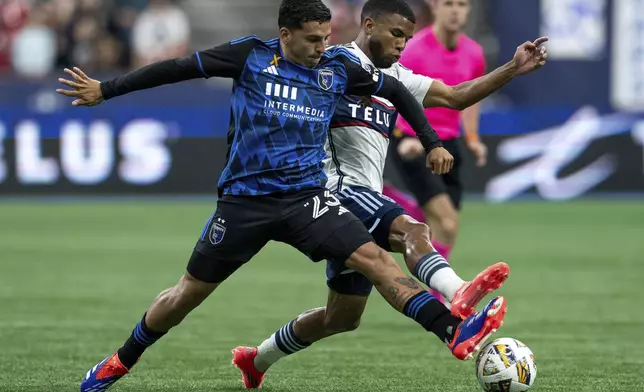 San Jose Earthquakes' Hernan, left, and Vancouver Whitecaps' Pedro Vite, right, vie for the ball during the first half of an MLS soccer match in Vancouver, British Columbia, Saturday, Sept. 14, 2024. (Ethan Cairns/The Canadian Press via AP)