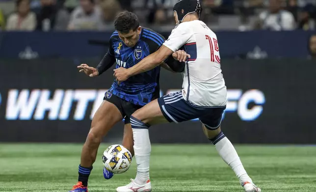 San Jose Earthquakes' Hernan, left, and Vancouver Whitecaps' Bjorn Inge Utvik (15) vie for the ball during the first half of an MLS soccer match in Vancouver, British Columbia, Saturday, Sept. 14, 2024. (Ethan Cairns/The Canadian Press via AP)