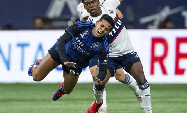 San Jose Earthquakes' Hernan, left, and Vancouver Whitecaps' Ralph Priso, right, collide as they vie for the ball during the first half of an MLS soccer match in Vancouver, British Columbia, Saturday, Sept. 14, 2024. (Ethan Cairns/The Canadian Press via AP)